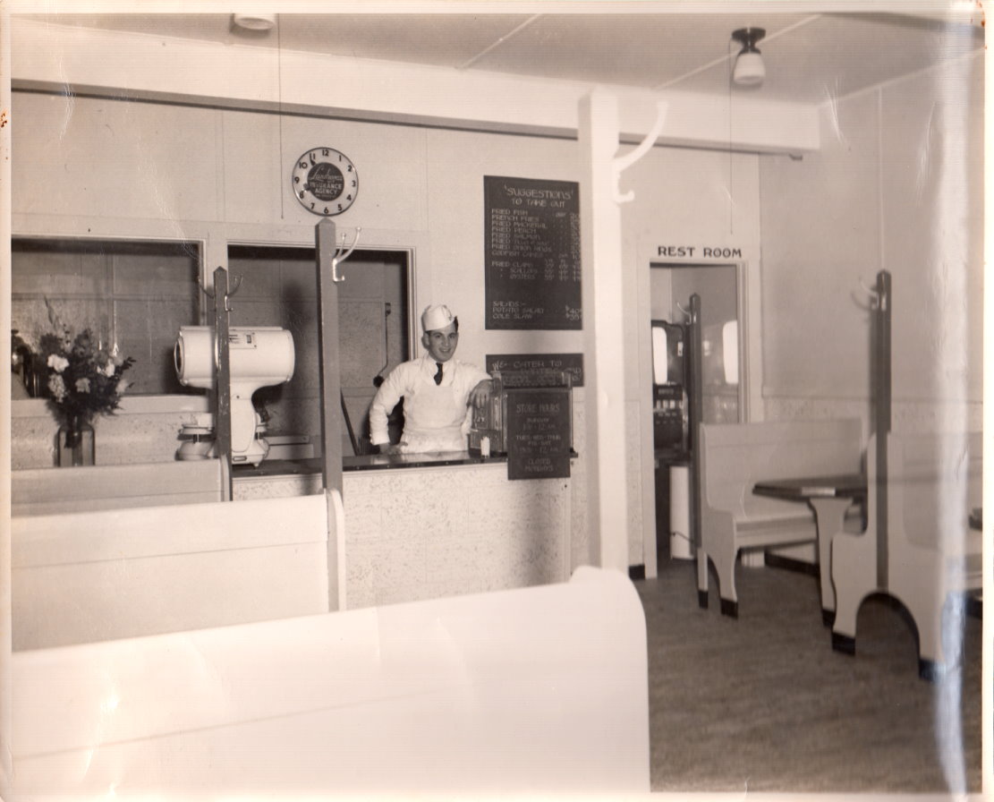 Saul Gordon proprietor of Gordon's Fried Sea Foods standing at the counter in his shop circa 193?