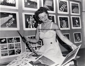 1950's photograph of Ilene Woods reviewing Disney sketches.